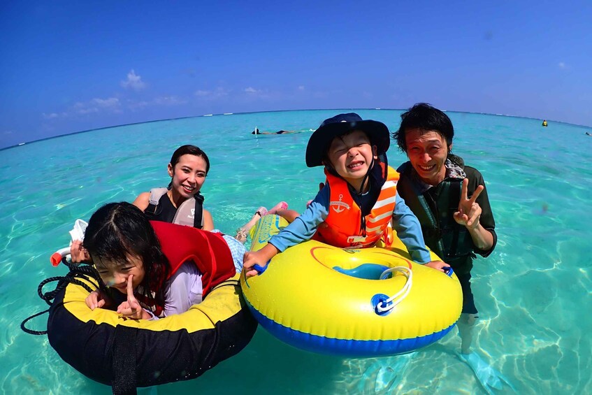 People floating on a clear turquoise sea with a bright blue sky. 2