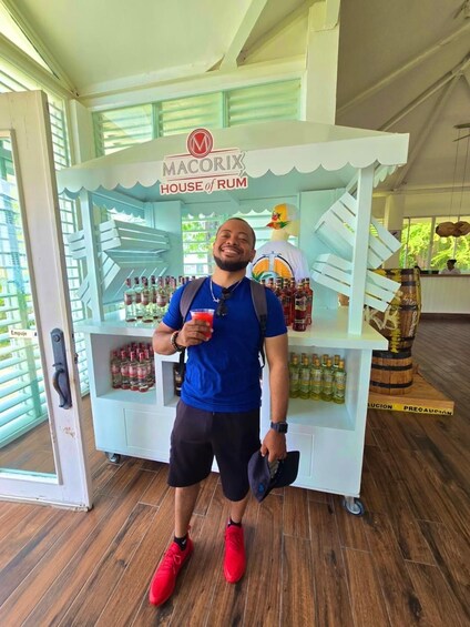 Henkilö seisoo Macorix House of Rum -kioskin edessä. Kioskissa on esillä erilaisia rommipulloja ja koristeellinen ankka. 4