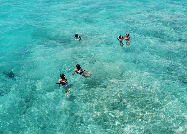 Personas haciendo snorkel en aguas turquesas cristalinas. 3