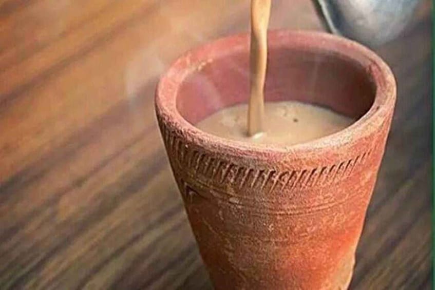 A clay cup with a liquid being poured into it. 1