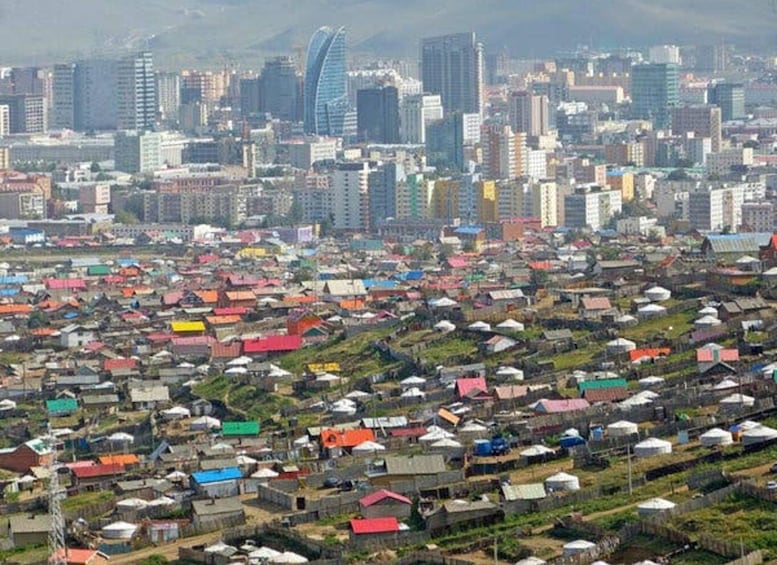 A densely populated urban area with a mix of colorful low-rise housing and modern high-rise buildings. 4