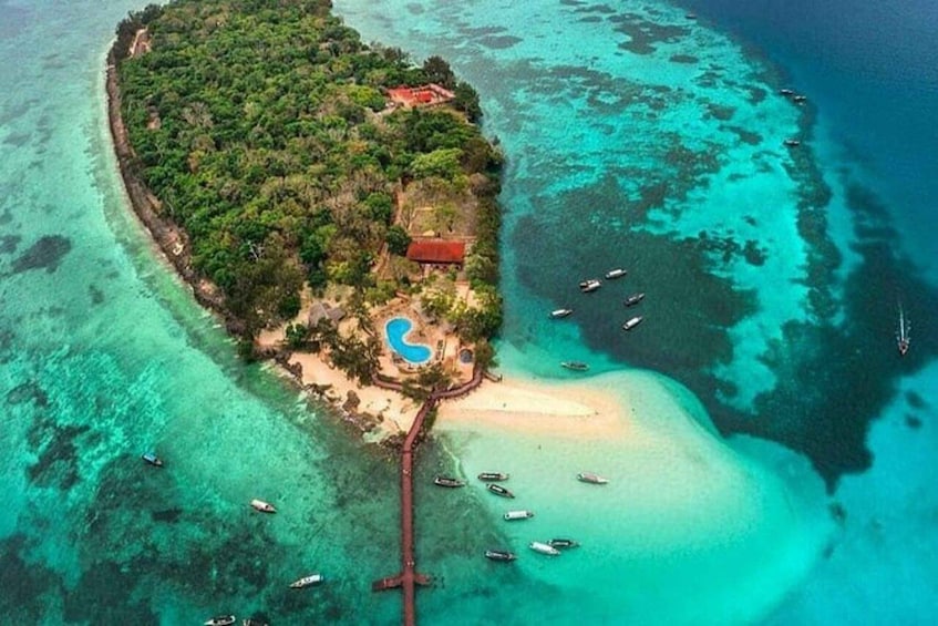 Une île dotée d’une piscine, de bateaux et d’un bâtiment au toit rouge. 1