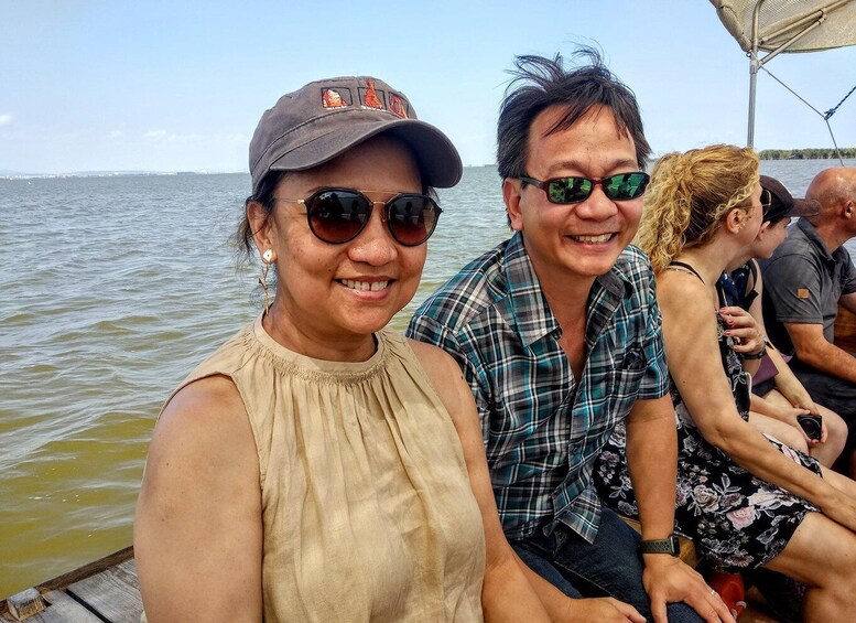People on a boat with a body of water and a distant shoreline in the background. 2