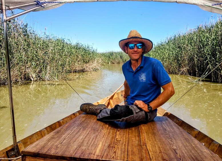 A man in a boat on a river surrounded by dense vegetation. 5