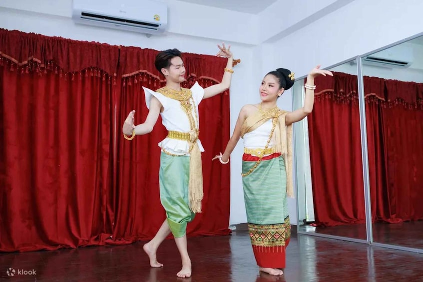 Two people performing a dance in a room with red curtains and a mirror. 1