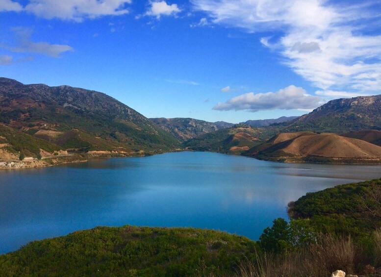 A serene lake surrounded by mountains under a clear sky. 2