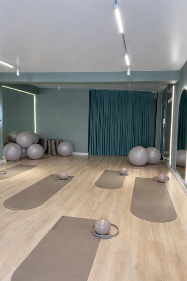 A fitness studio with exercise mats, yoga balls, and a mirror. 3