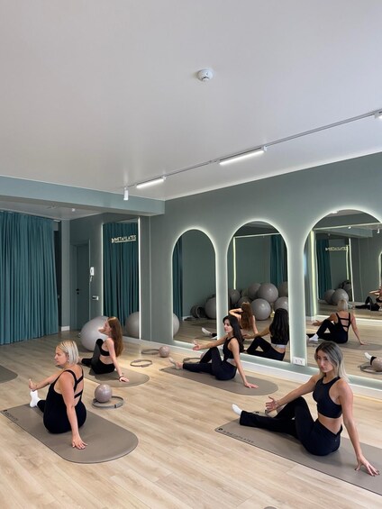 A fitness studio with mirrored walls, exercise balls, and yoga mats. 1