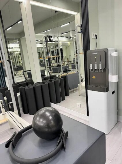 A gym with exercise equipment, a water dispenser, and a large mirror. 5