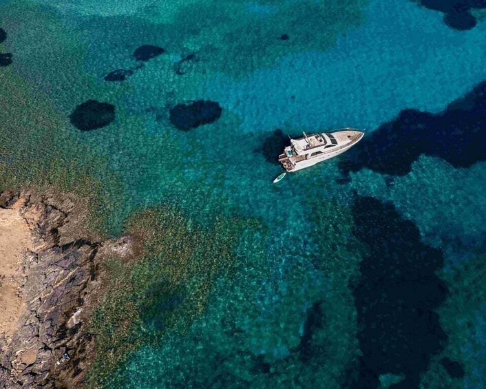 A boat on clear turquoise water with rocky shorelines. 2