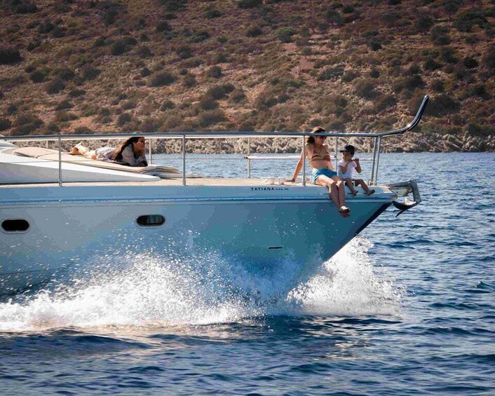 A boat with people on board, water, and a hilly landscape in the background. 5