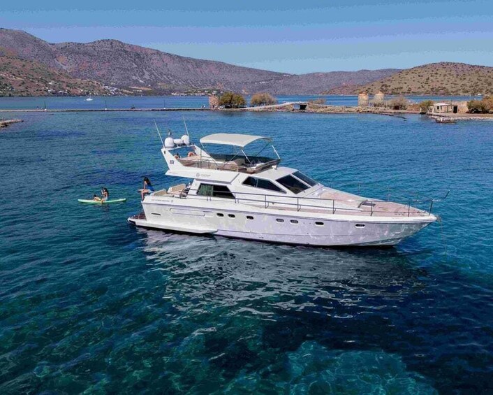 A white yacht on clear blue water with a mountainous landscape in the background. 5