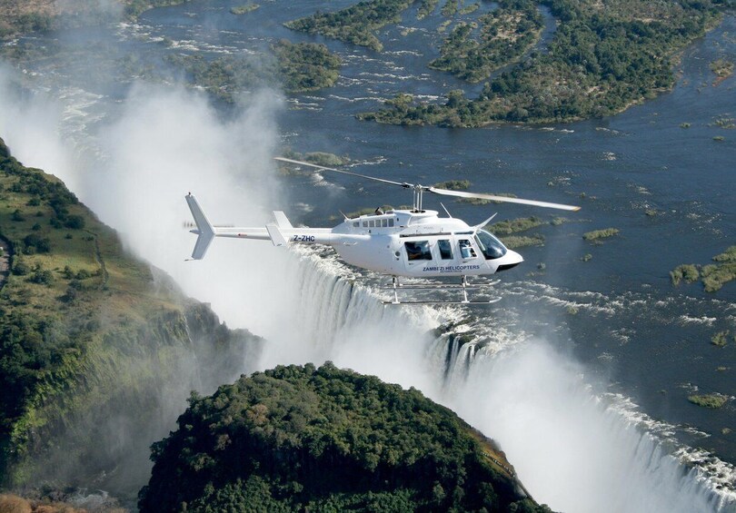 A helicopter flying over a waterfall. 3