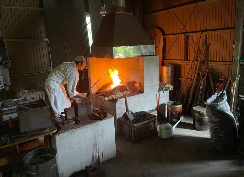 A blacksmith at work in a workshop with a forge, anvil, and various tools. 3