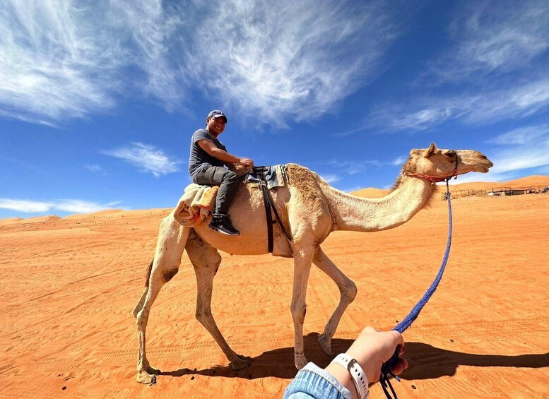 A person riding a camel in a desert landscape. 5