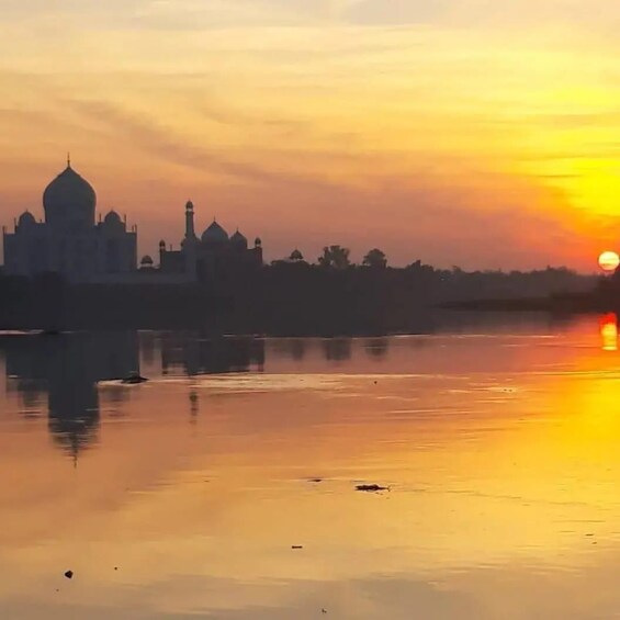 A sunset over a calm river with a prominent domed building in the background. 4