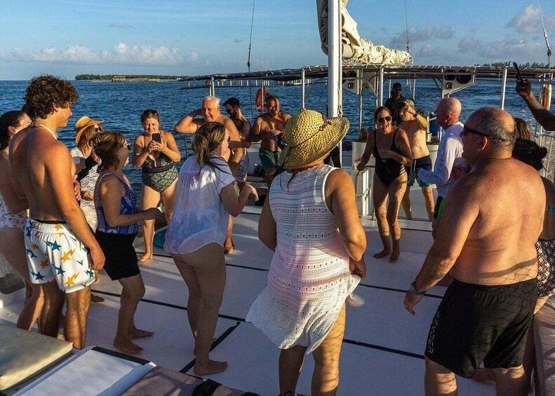A group of people on a boat, some wearing hats, with a calm sea and a clear sky in the background. 2