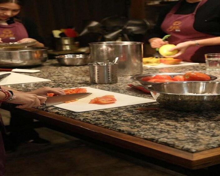 A kitchen counter with vegetables being prepared, including tomatoes and a cutting board. 5