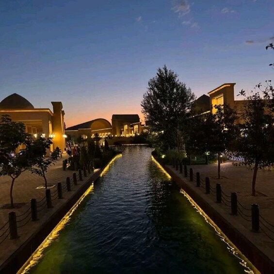 A canal with water, trees, and buildings at dusk. 4