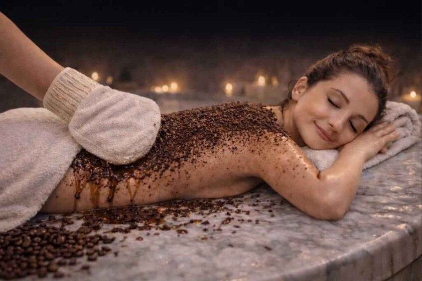 Een persoon ligt op een massagetafel, omringd door koffiebonen. 4