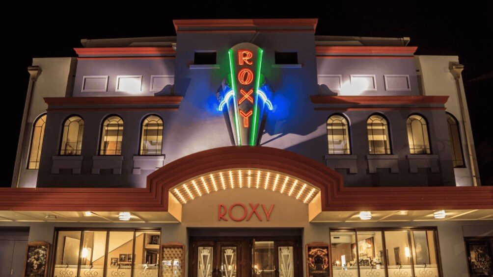A building with a neon sign reading 'ROXY' and a marquee with lights. 5
