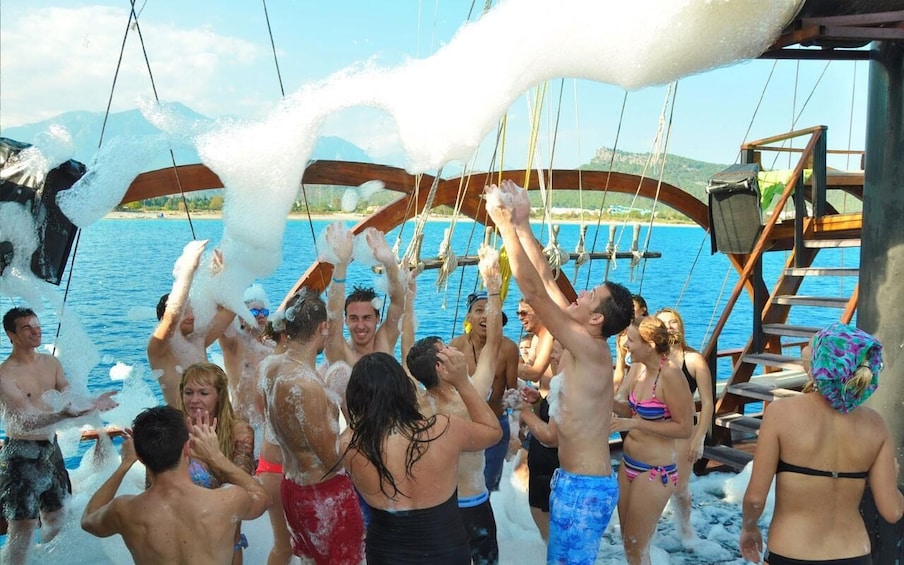 A group of people on a boat with water splashing around them. 1