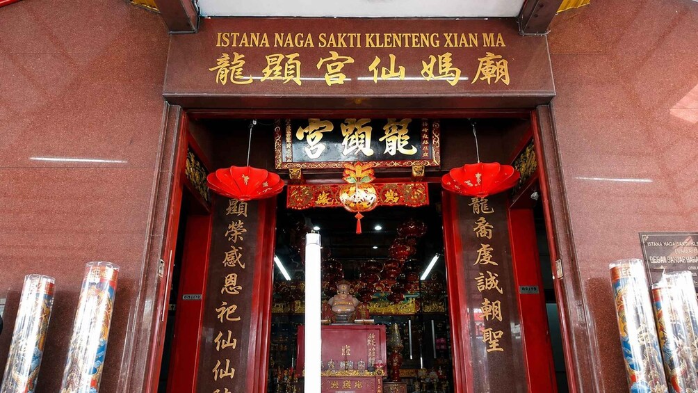 A traditional Chinese temple entrance with red lanterns and golden inscriptions. 2