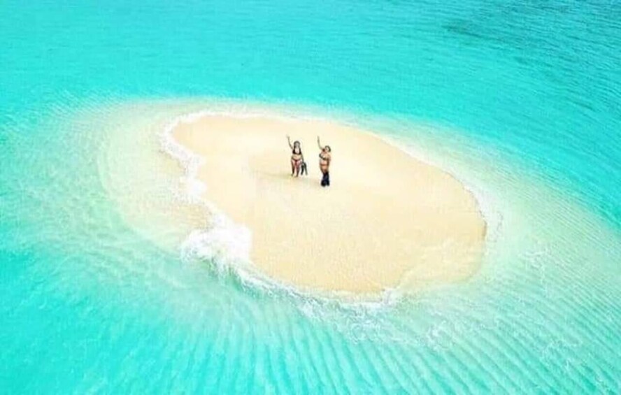 A small island with two people standing on the beach. 5
