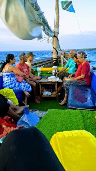 A group of people sitting on a boat with a view of the ocean. 2