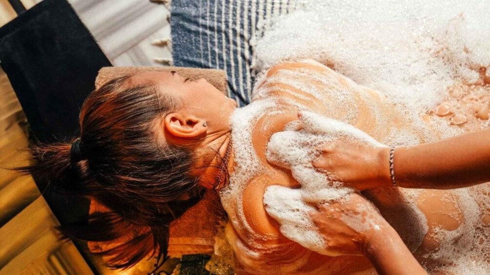 A person receiving a facial treatment with foam. 1