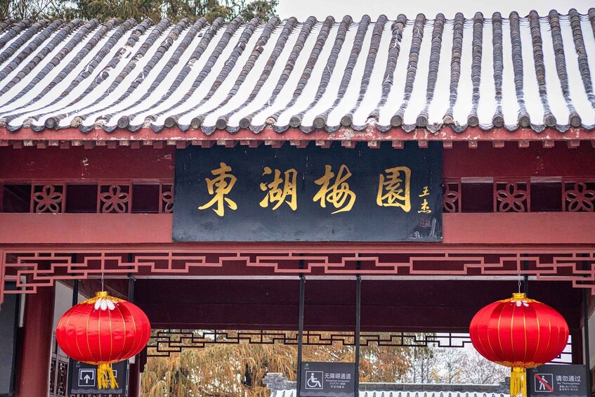 A traditional Chinese building with a tiled roof and red lanterns. 1