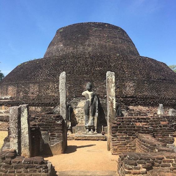 Ancient brick ruins with a large dome-shaped structure in the background. 4