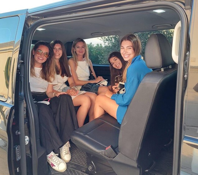Five people sitting inside a van with a blue exterior. 4