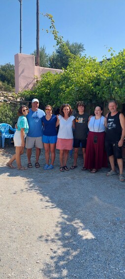 A group of people standing outdoors with a gravel ground, trees, and a building in the background. 5