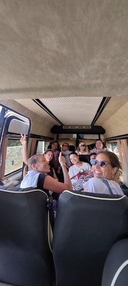 A group of people inside a vehicle with a patterned ceiling and windows. 3