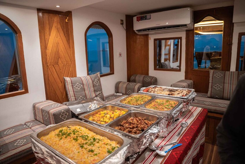 A buffet table with various dishes, a wooden door, and arched windows. 5
