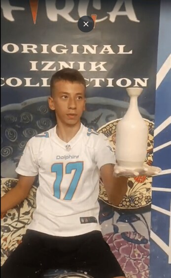 A person in a white sports jersey with the number 17, holding a white object. 4