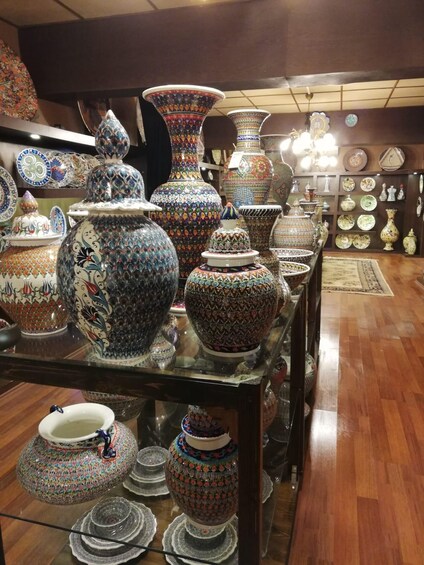 A variety of intricately patterned ceramic vases and bowls on display in a shop. 1
