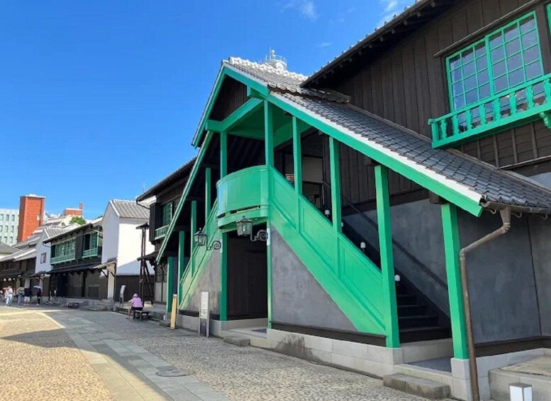A traditional Japanese building with a green staircase and wooden structure. 1