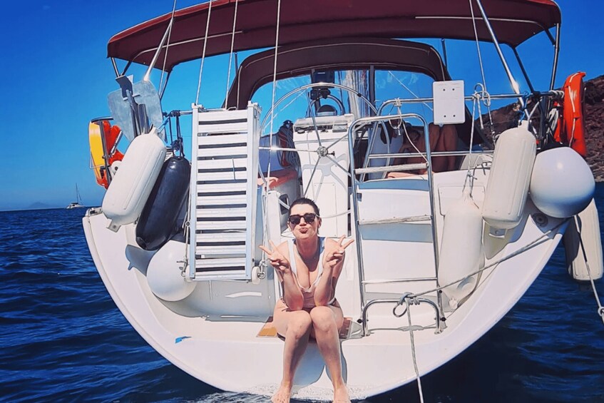 A person sitting on a boat with a clear blue sky and calm sea in the background. 3