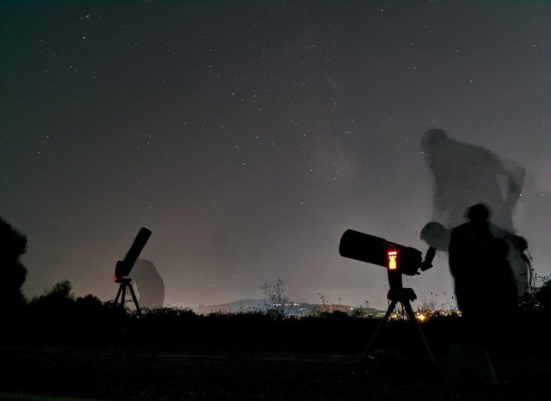 A night sky with stars, a telescope, and a person observing. 3