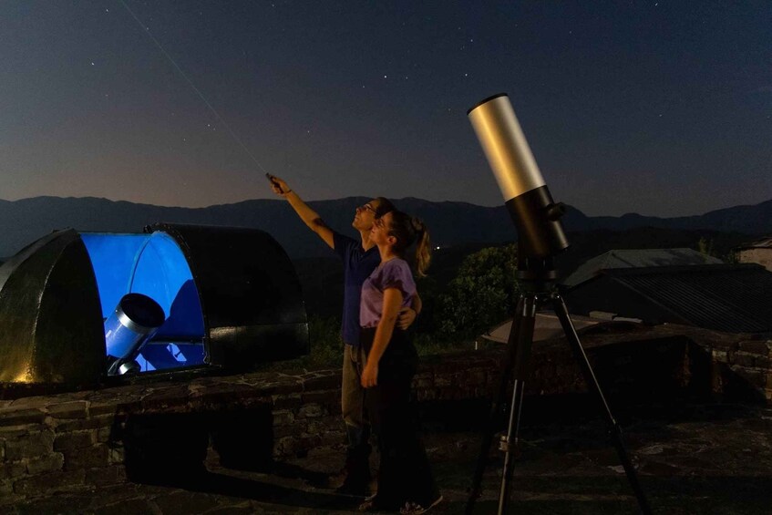 Two people observing the night sky with a telescope. 4