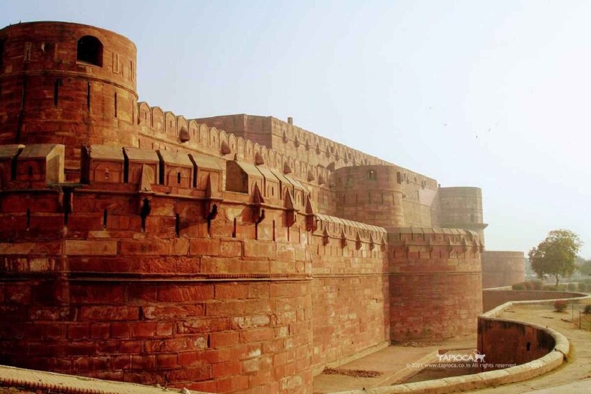 A large, historic fort with red brick walls and a prominent round tower. 2
