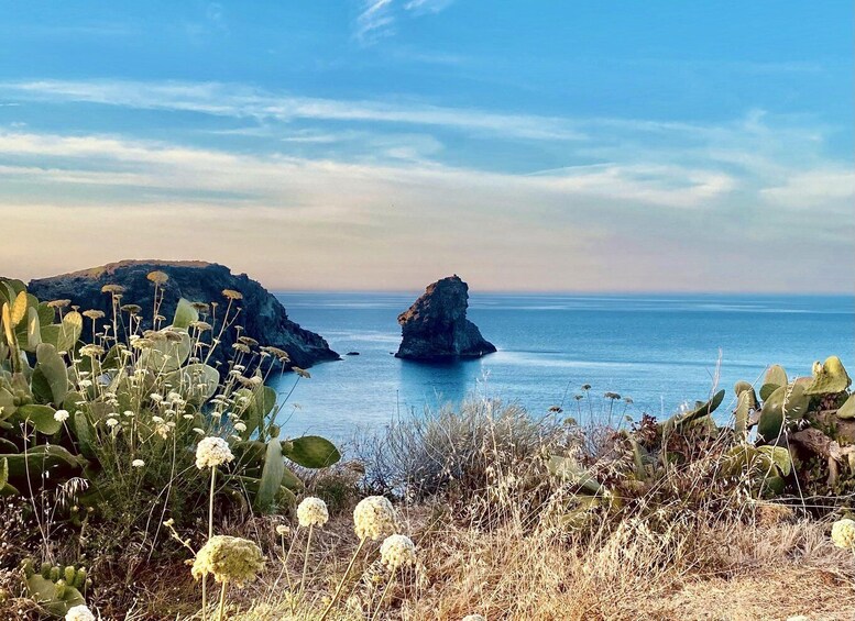 A coastal landscape with rocky outcrops and a clear blue sea. 3
