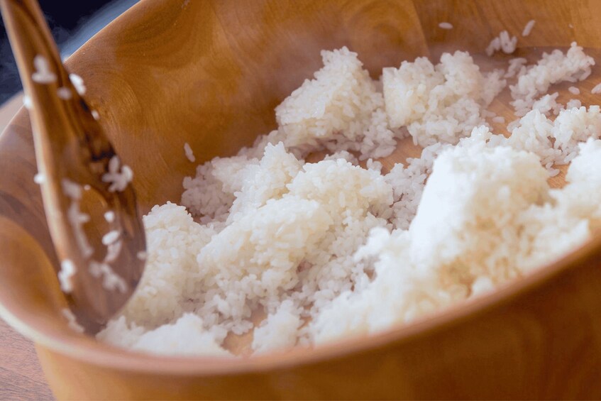 A wooden bowl filled with white rice. 5