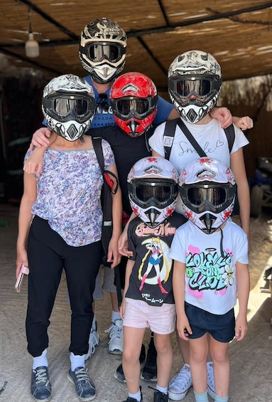 A group of people wearing helmets, standing under a shelter. 2