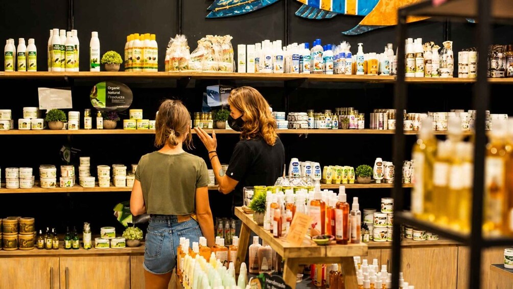 A store with shelves stocked with organic products and a woman examining items. 2