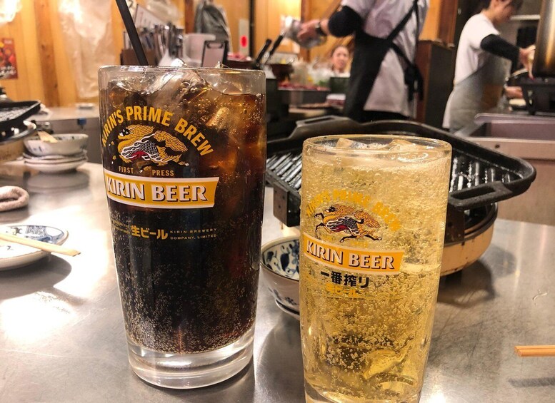 Two glasses of Kirin beer, one dark and one light, on a table in a restaurant. 3