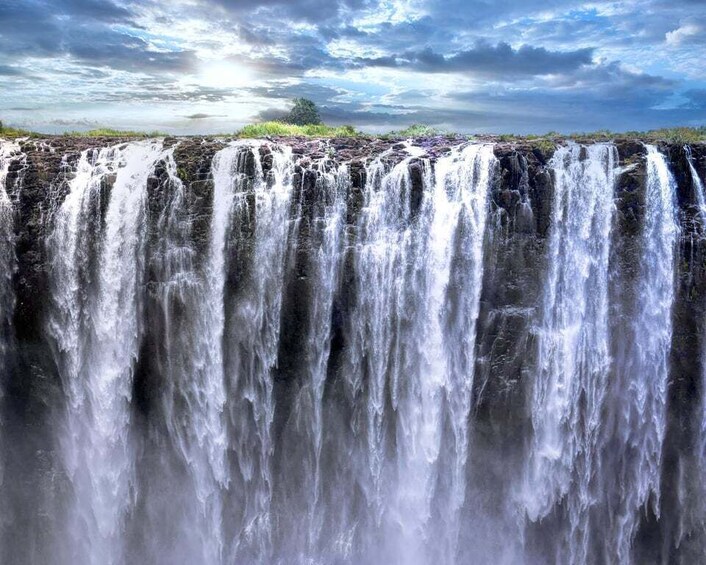 A multi-tiered waterfall cascading over a rocky cliff. 5
