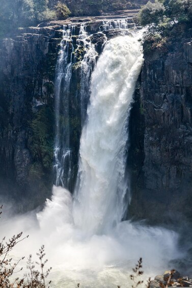 A large waterfall cascading down a rocky cliff. 4